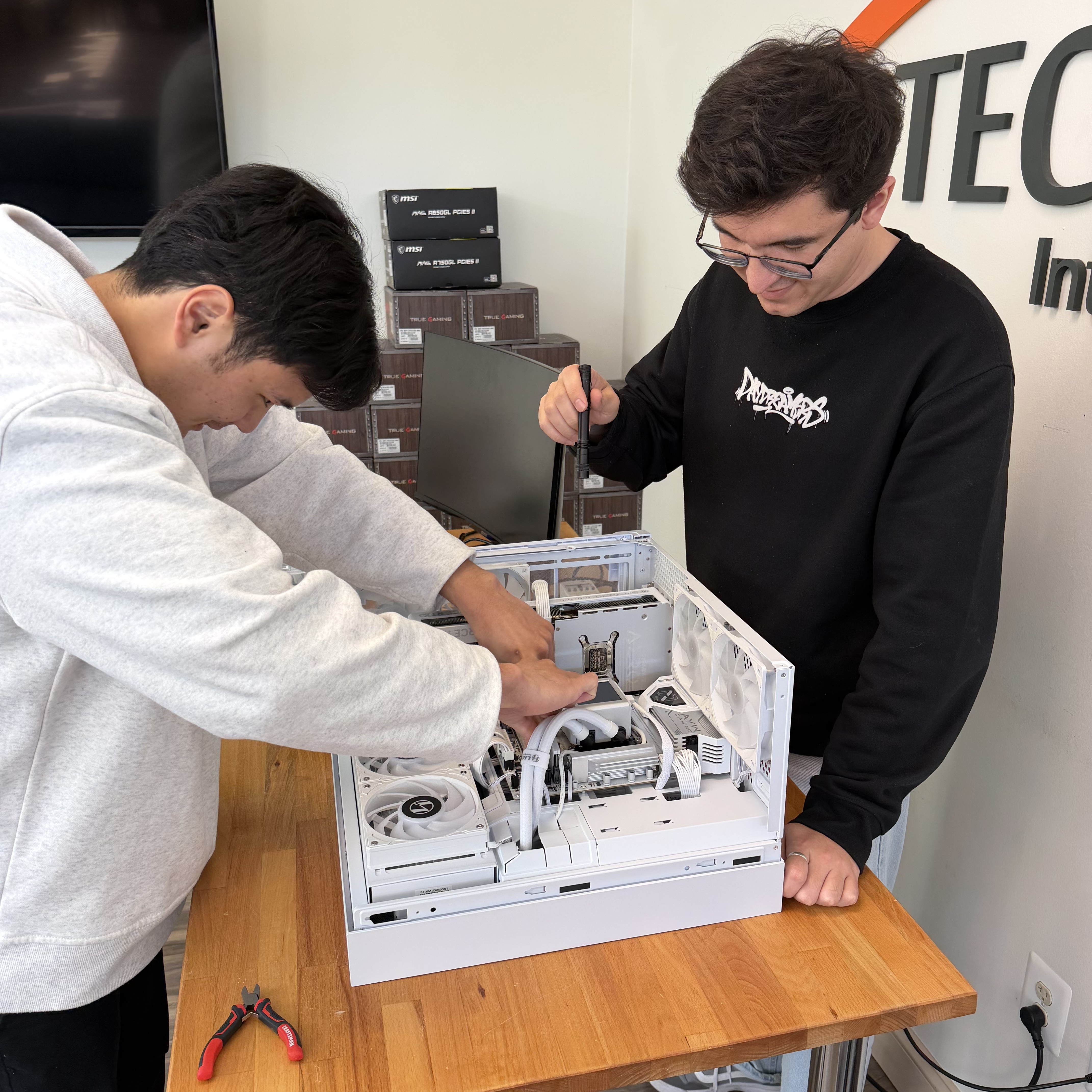 Shak and Anish assembling a custom white liquid-cooled gaming PC at Fateka Computer Store in Herndon, VA